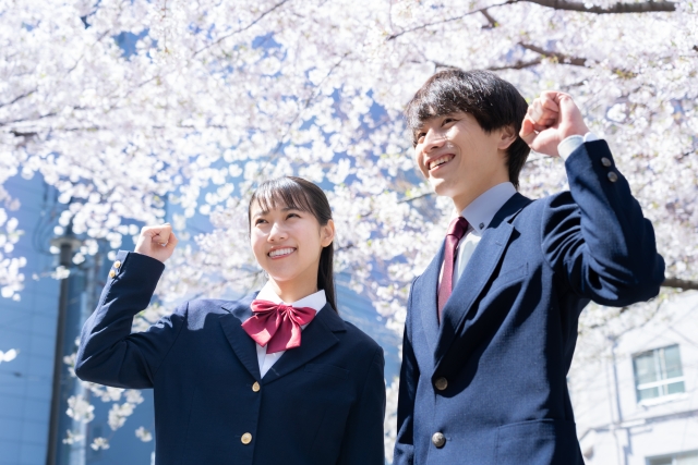 桜の下でポーズをとる高校生